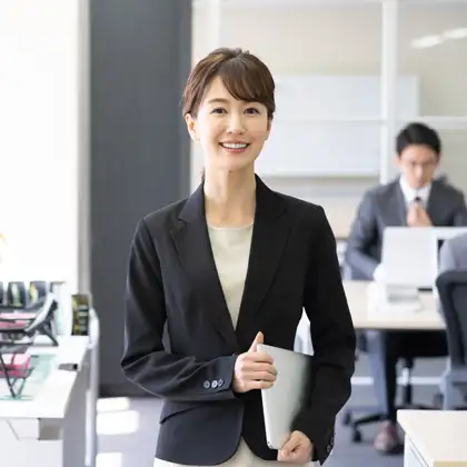 タブレットを持ち微笑む女性ビジネスパーソン。LP18万円〜、AI検索対応も全プラン標準搭載。ご予算に合わせた料金プランのご案内