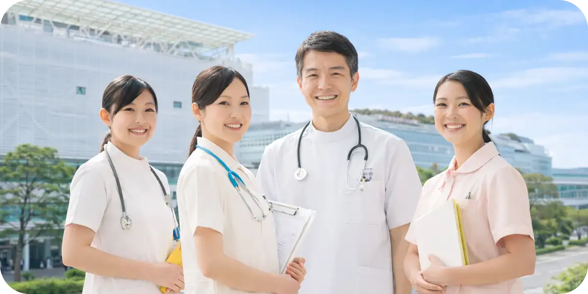 青空の下で笑顔で並ぶ医師や看護師たちの医療チーム（二子玉川のクリニック向けAI検索・ウェブ集客戦略）